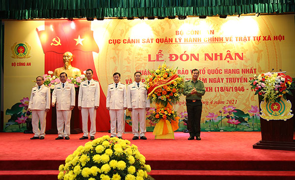 Thay mặt Đảng ủy Công an Trung ương, Thứ trưởng Lê Tấn Tới tặng hoa cho Cục Cảnh sát QLHC về TTXH.