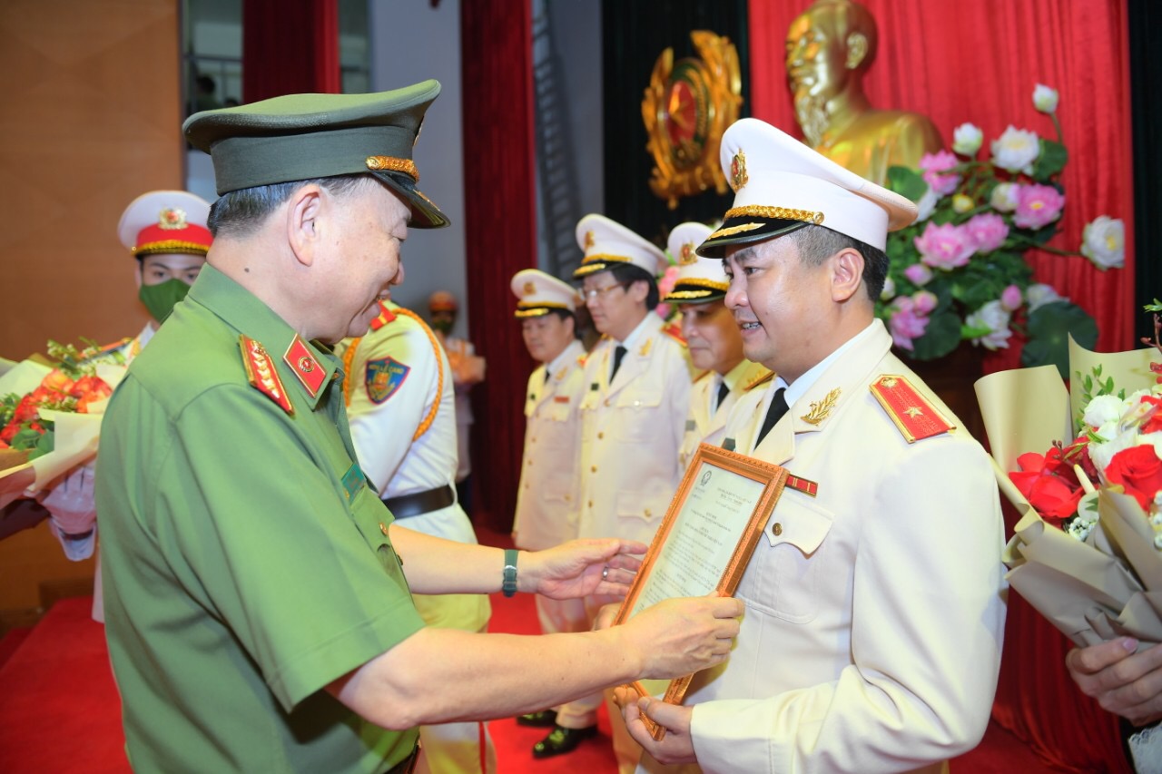 Đại tướng Tô Lâm, Ủy viên Bộ Chính trị, Bộ trưởng Bộ Công an trao quyết định và tặng hoa chúc mừng Thiếu tướng Phạm Công Nguyên, Cục trưởng Cục Cảnh sát Quản lý hành chính về trật tự xã hội